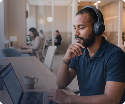 Candidato utilizando notebook e fones de ouvido em ambiente de estudo